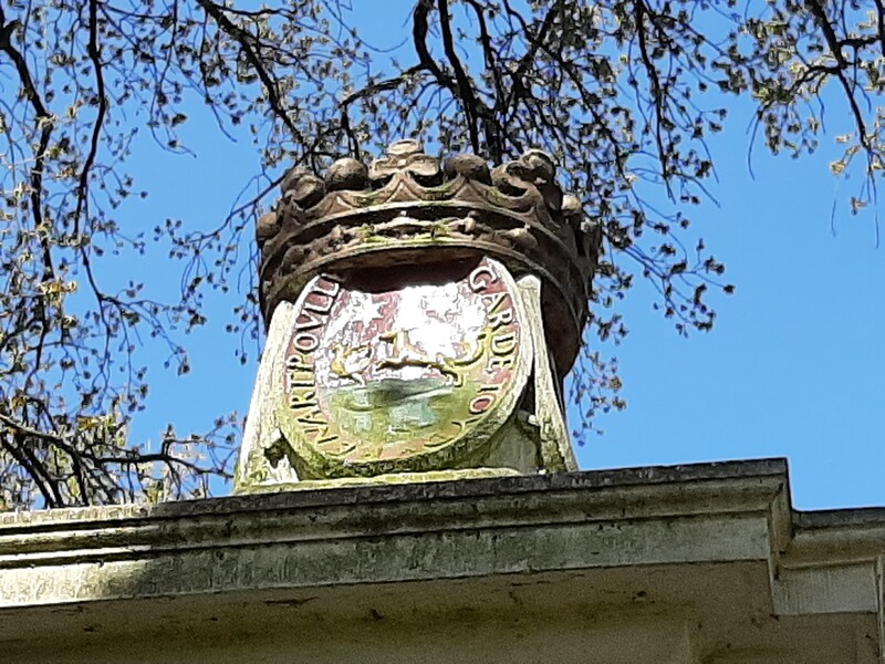 Het wapen Poulle op het hek bij de achteringang van het park
