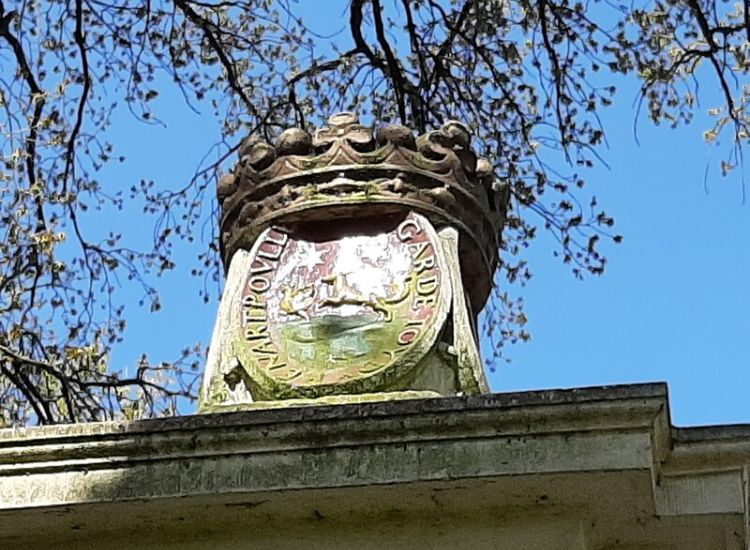 Het wapen Poulle op het hek bij de achteringang van het park