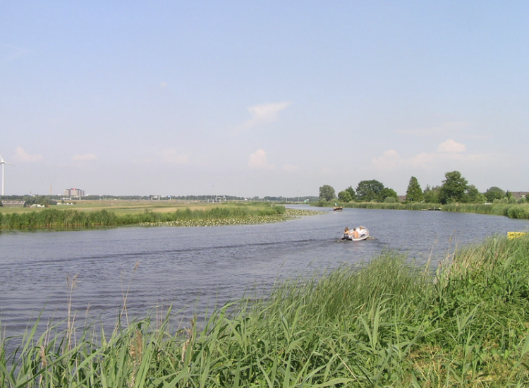 De landelijke omgeving van de Holendrecht met links de eerste contouren van Amsterdam